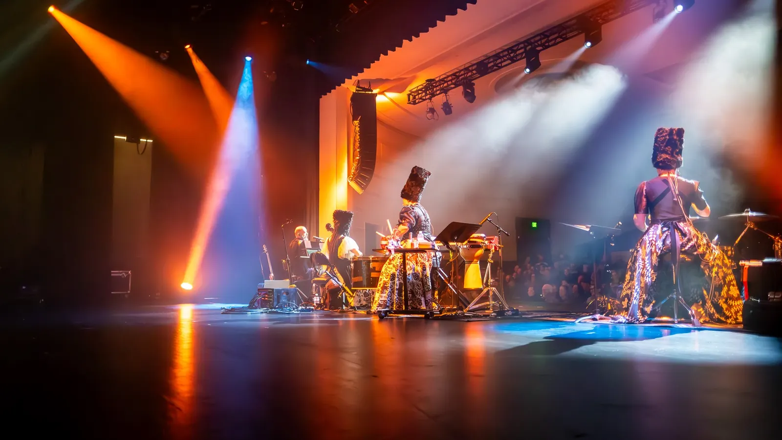 Full band beneath orange and blue lighting