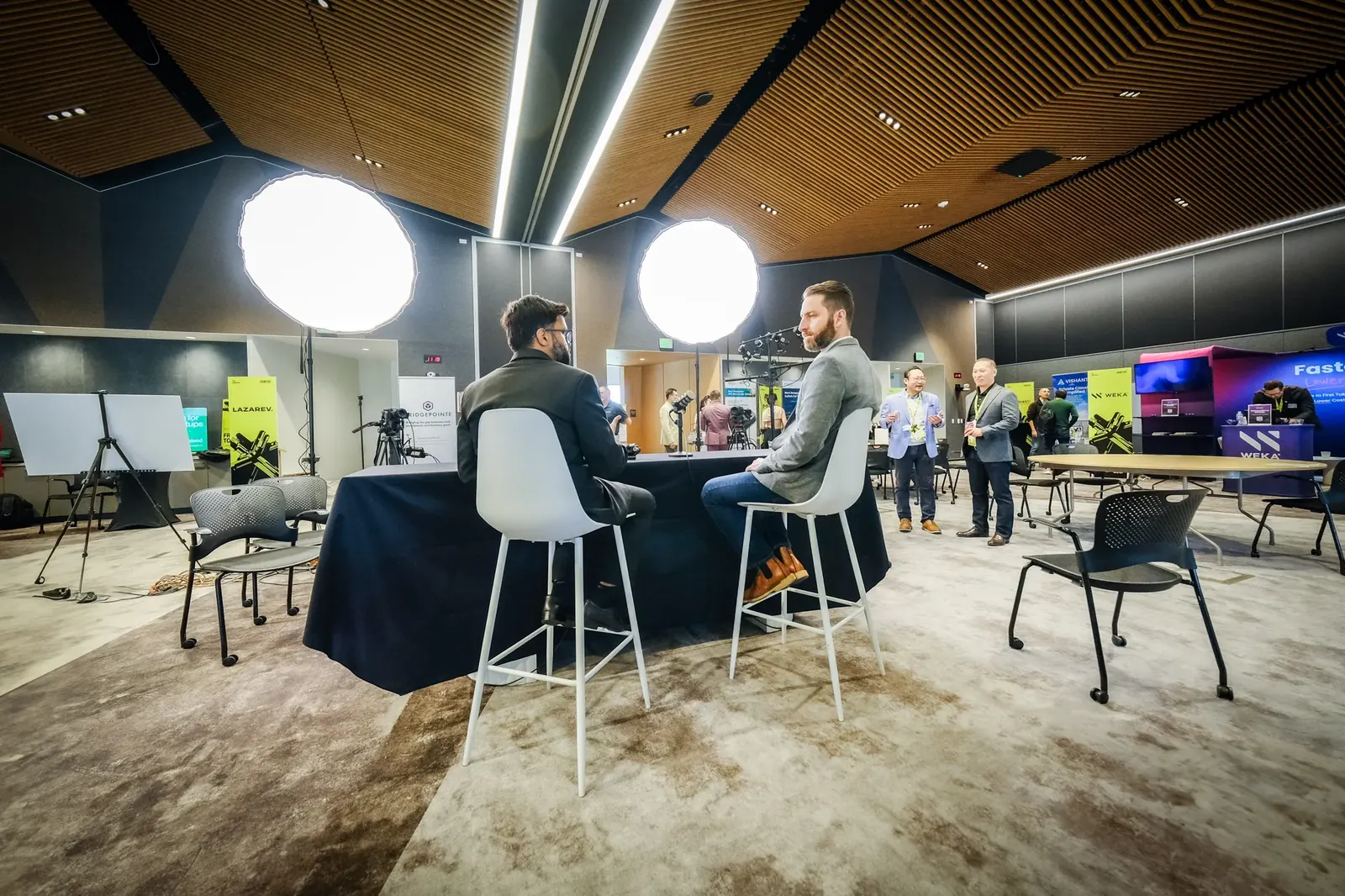 Reverse angle showing interview guests, lights and the surrounding exhibition