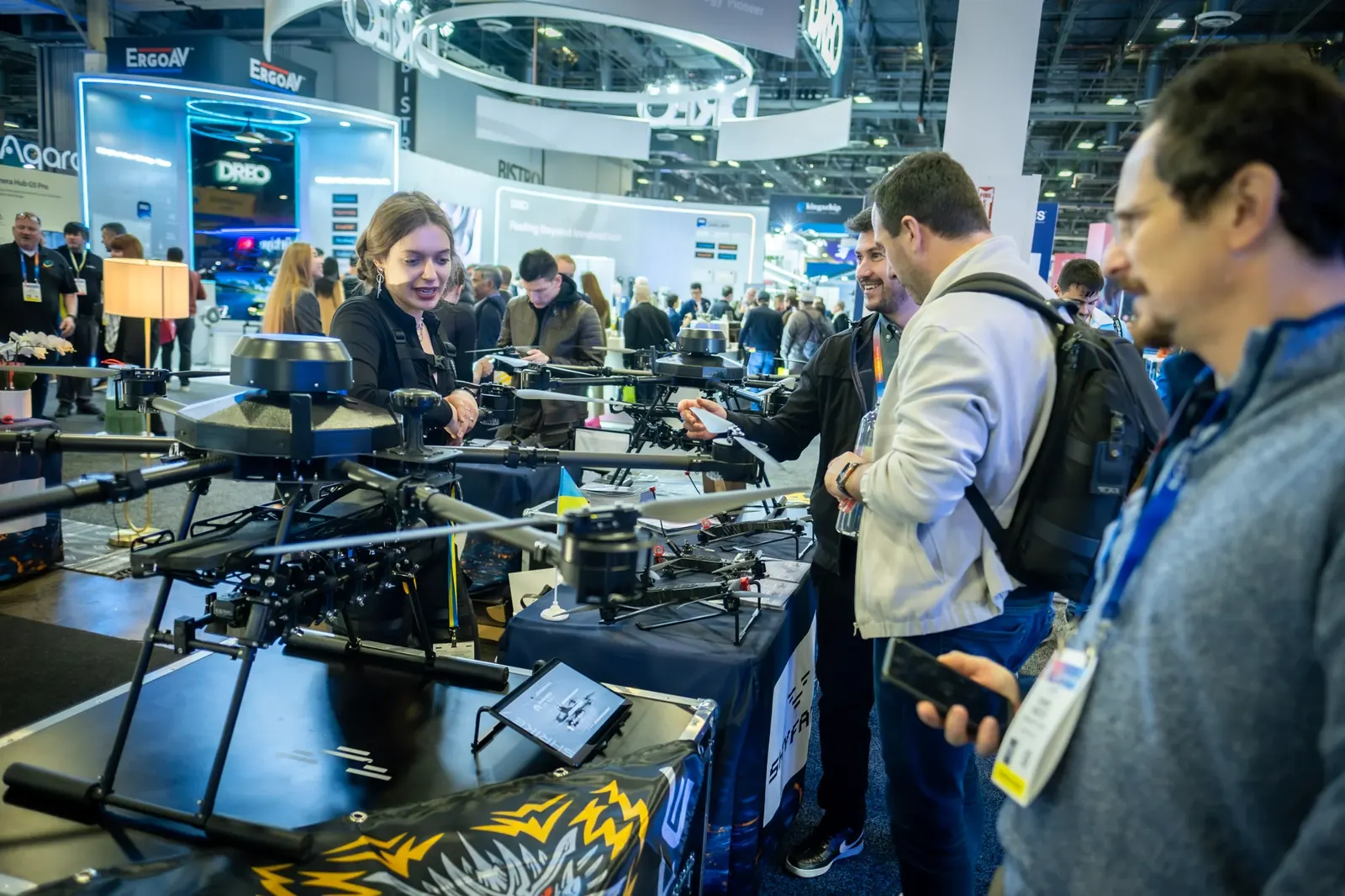 Visitors discussing technology at an exhibition booth